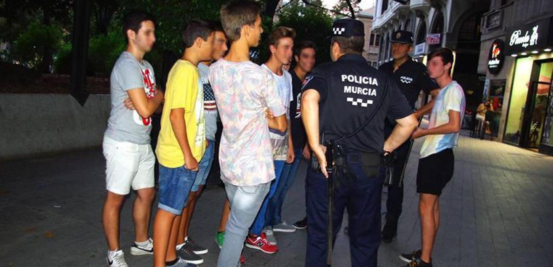 Agentes de policía conversando con un grupo de jovenes.