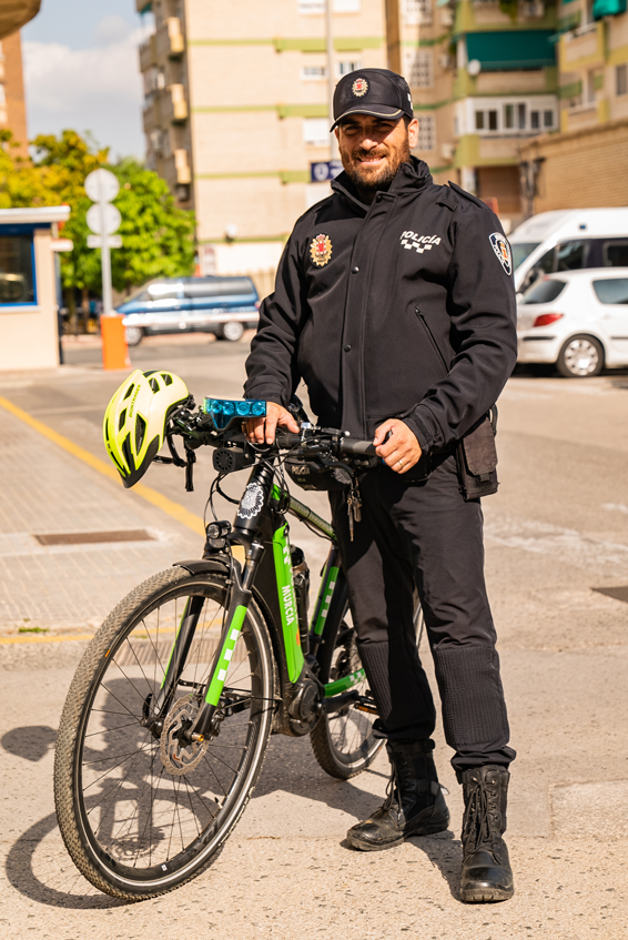 Agente de la patrulla ecológica con bicicleta con uniforme de invierno