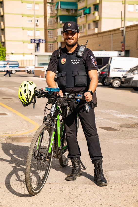 Agente de la patrulla ecológica con bicicleta con uniforme de verano