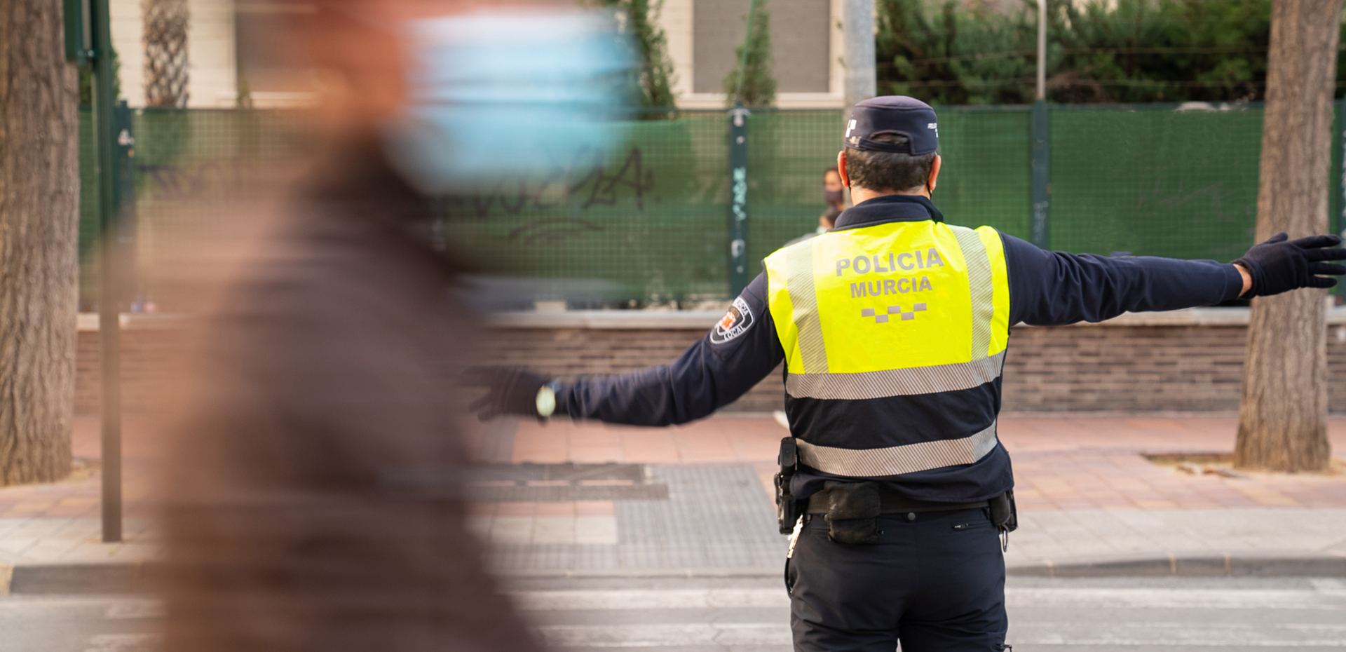 Agente de policía regulando el tráfico en un paso de peatones