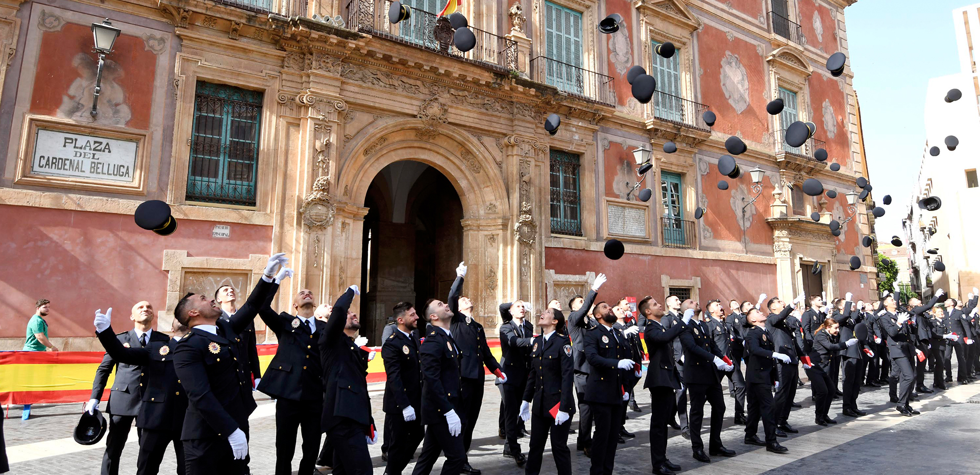 Nuevos agentes de policía lanzando sus gorras al aire tras tomar posesión de sus cargos