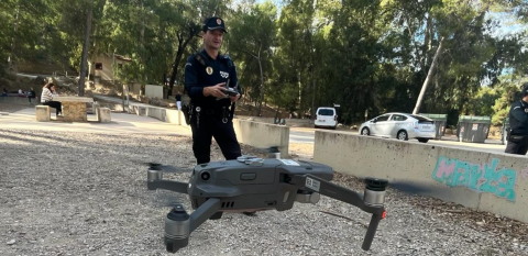 Agente de la Patrulla Ecológica manejando un dron que se ve en primer plano.