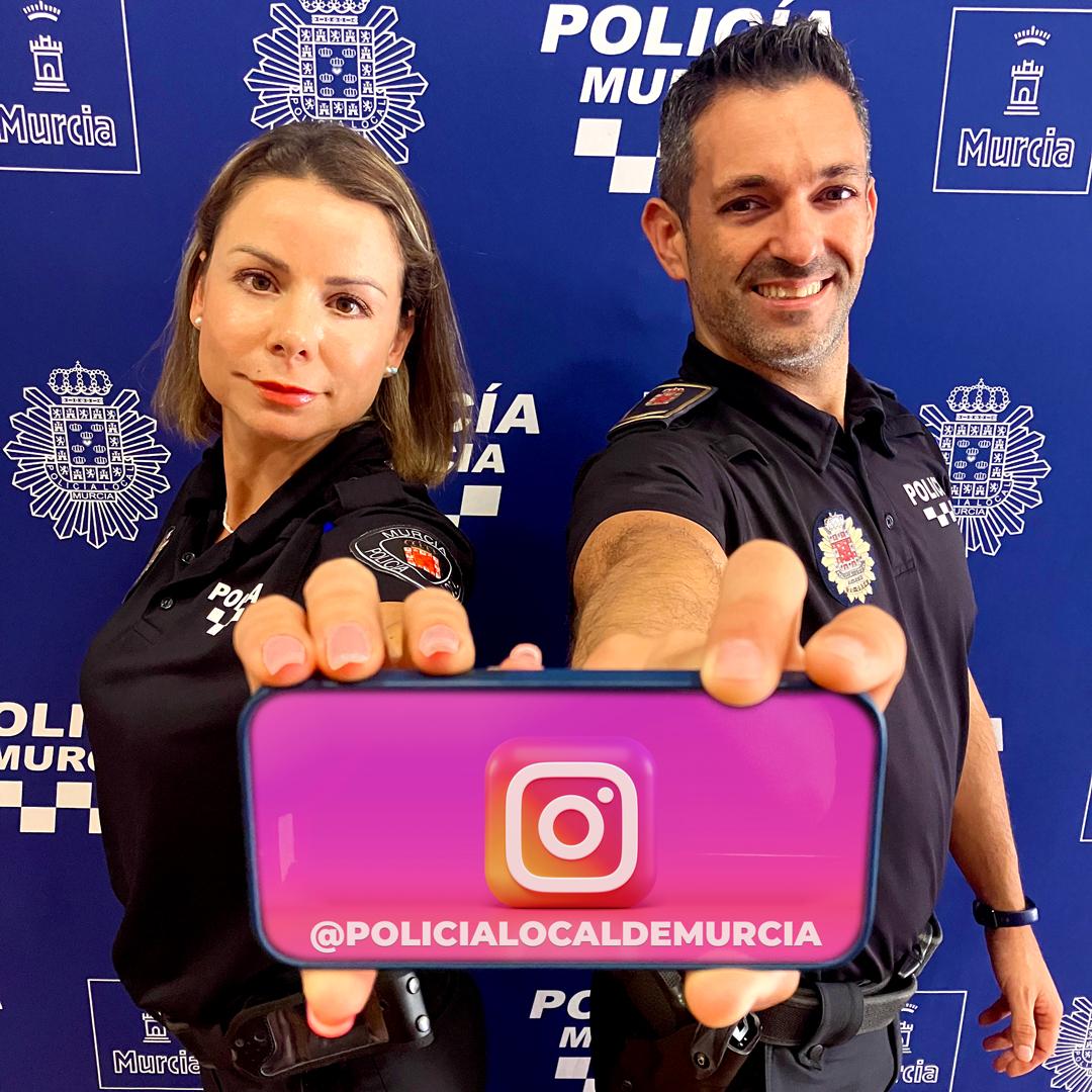 Dos policías sujetan un smartphone con el logo de instagram en la pantalla