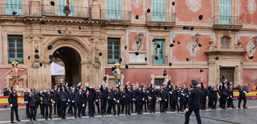 Los 56 nuevos agentes lanzan sus gorras al aire al concluir el acto